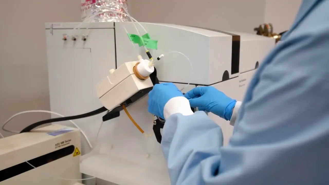 Gloved hands working on a mass spectrometer