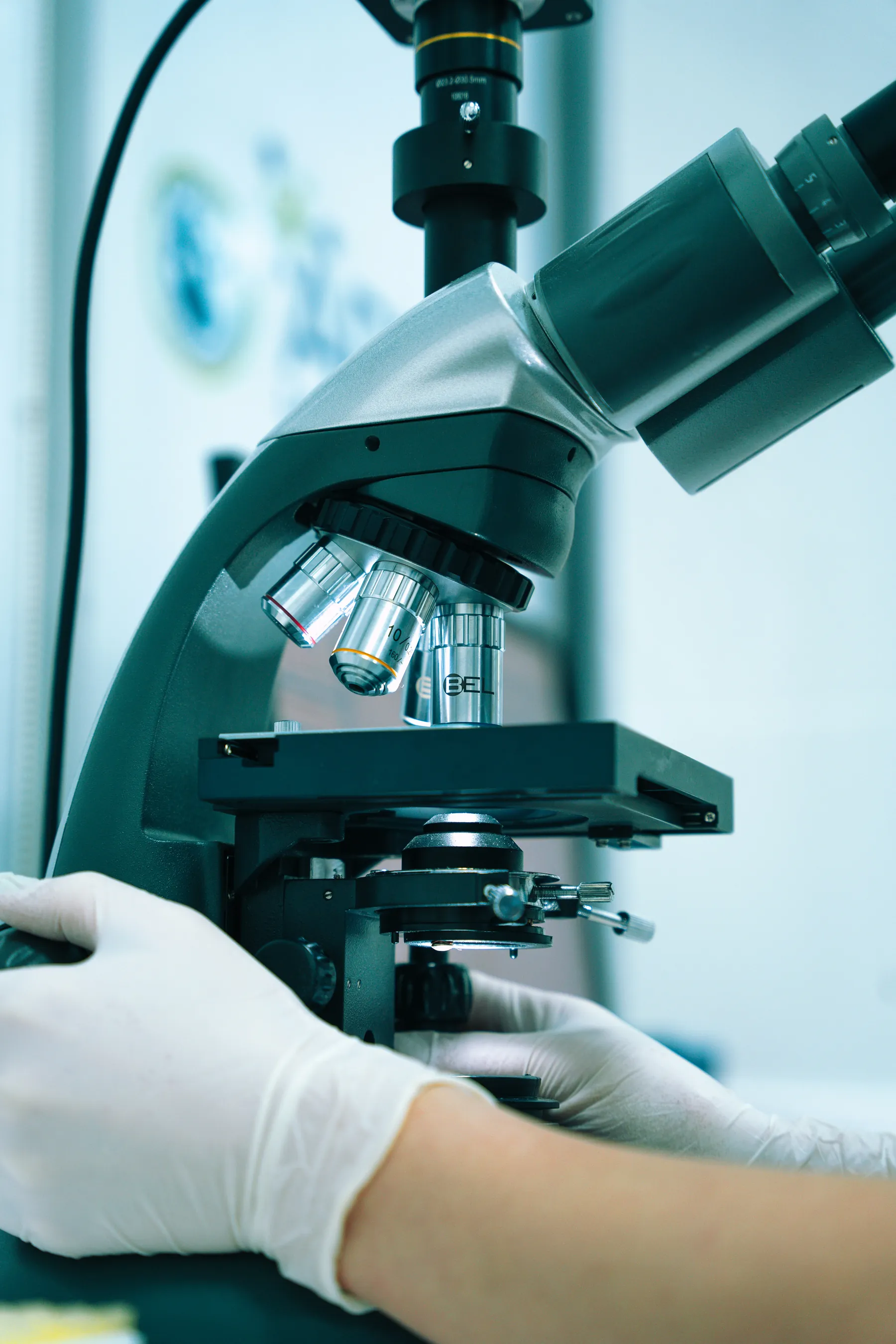Microscope and gloved hand in a laboratory